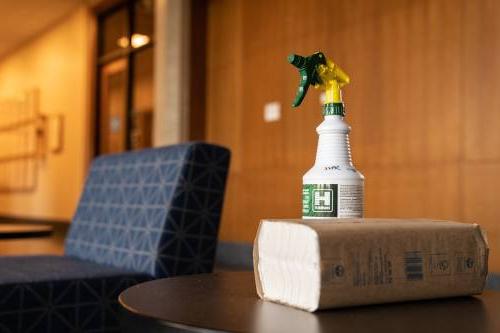 Cleaning spray bottle and stack of paper towels